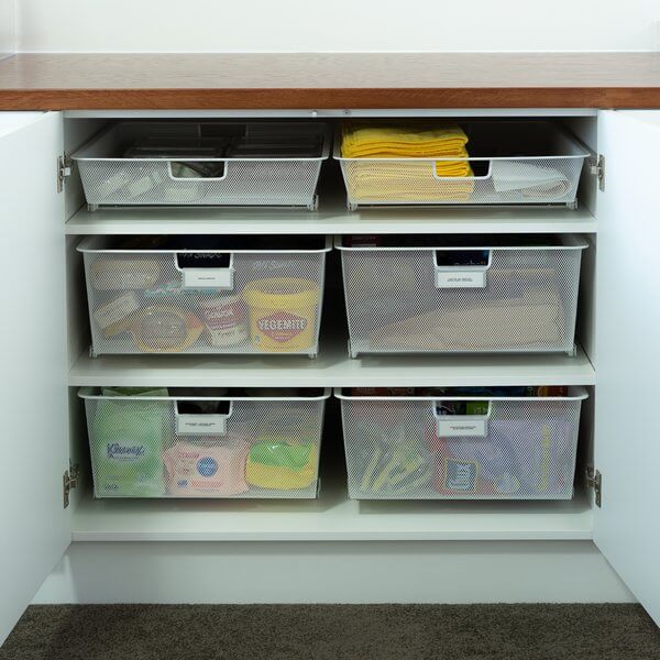 Six White Elfa Easy Gliders installed in a kitchen cupboard, with food containers, kitchen roll and pantry supplies stored inside