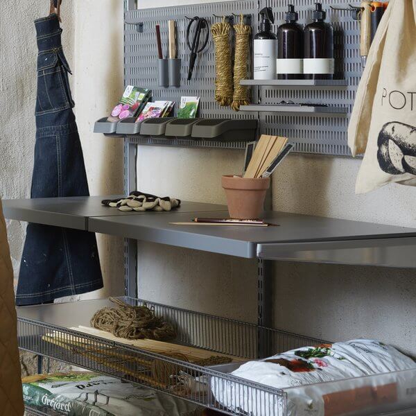 Two Grey Elfa Click In Work Benches installed in a garage workshop to organise gardening equipment and supplies