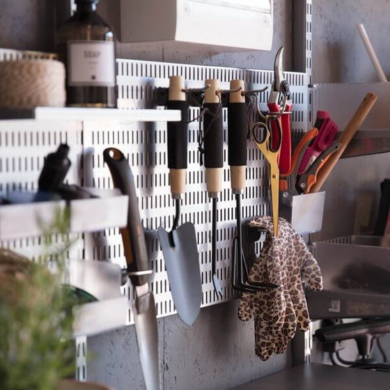 Small gardening tools stored on a Platinum Elfa Storing Board