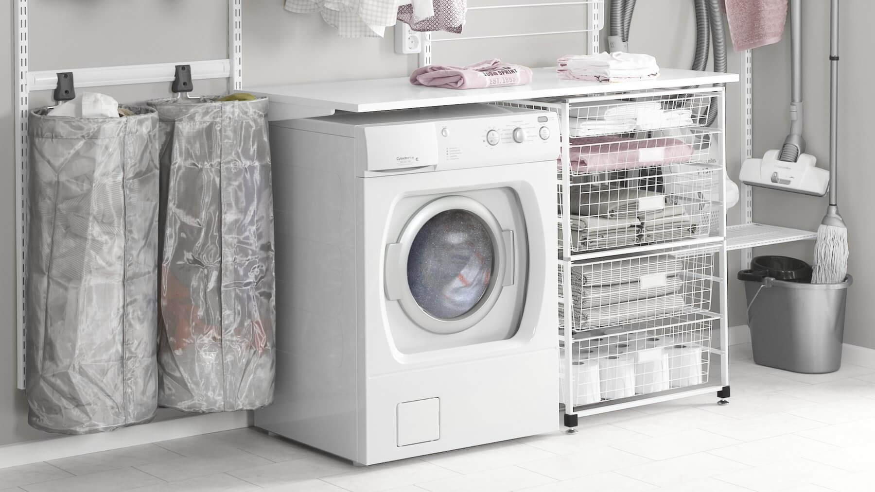 A laundry room fitted with White Elfa shelving and a Freestanding Drawer Kit