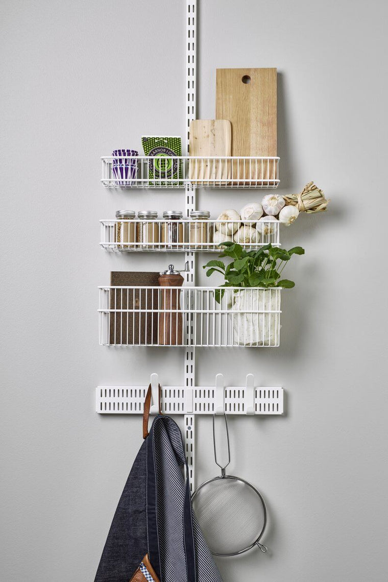 A White Elfa Utility Wall & Door system with Wire Utility Baskets, used for over-the-door kitchen storage